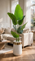 50-inch artificial Bird of Paradise plant in white and gold luxury pot in a bright modern living room