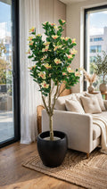 Artificial magnolia flower tree 55 inch in black pot in a luxury living room at night