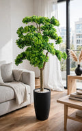 48-inch artificial bonsai tree with realistic green canopy and textured trunk in a black planter in a modern living room