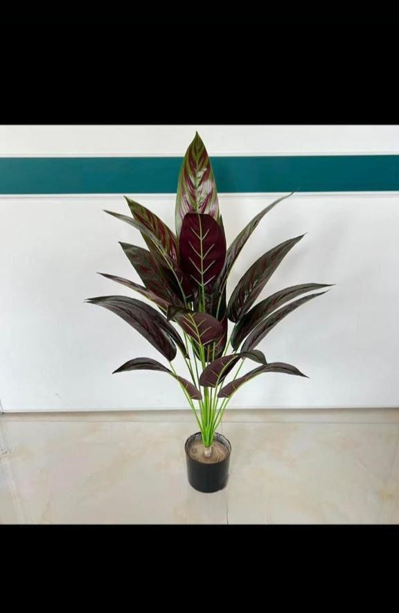 Artificial solid green indoor tropical plant in black nursery pot