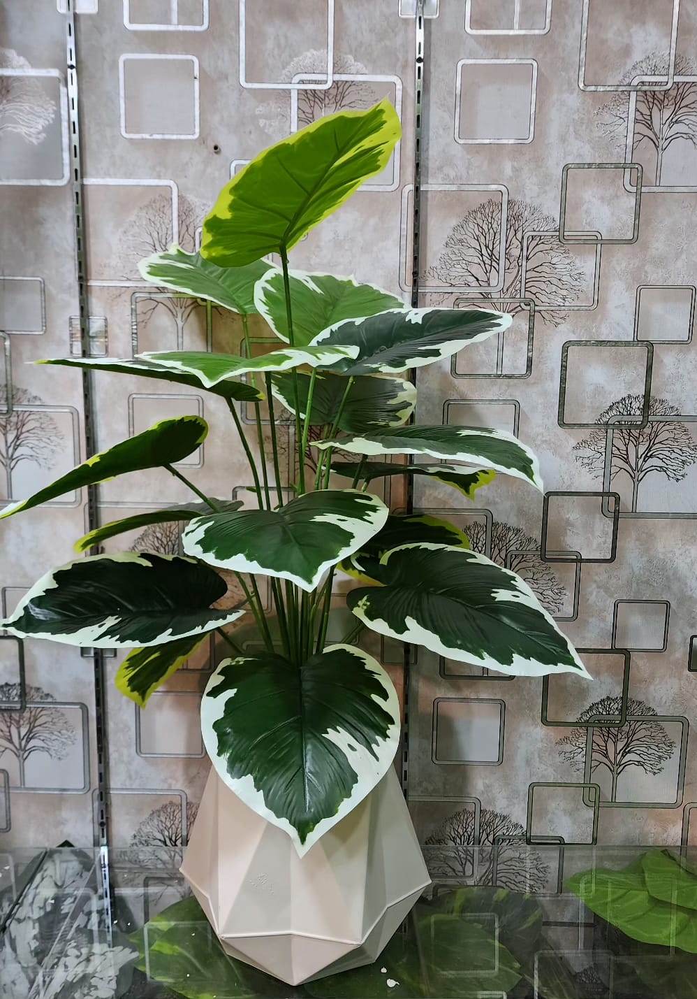 Artificial variegated plant with white-edged leaves in geometric pot