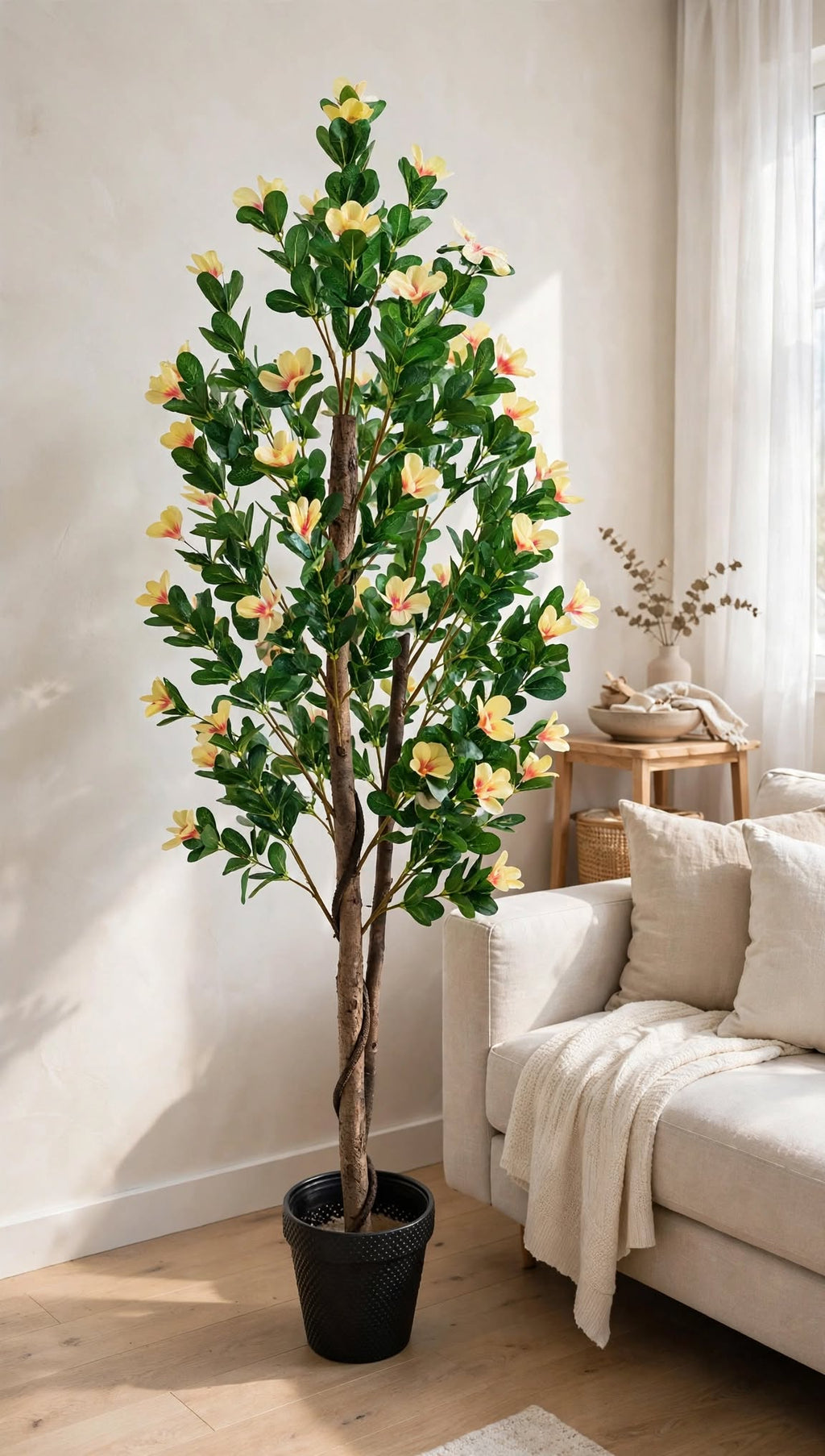 70 inch artificial Bougainvillea tree with yellow-cream flowers in black pot – styled next to a white sofa