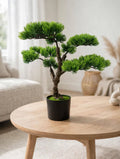 Artificial Pine Bonsai Tree 18 inch in black pot on a wooden coffee table in a modern living room