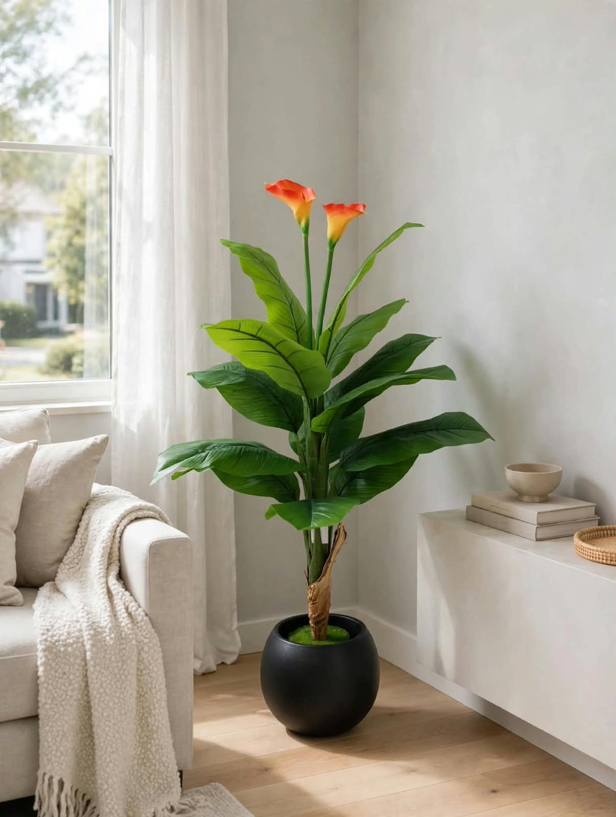 48-inch decorative floor plant with lush green leaves, orange flowers, and rounded black pot beside a sofa