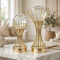 Pair of bubble crystal ball gold crown wire stand sculptures on a marble coffee table in a luxury living room