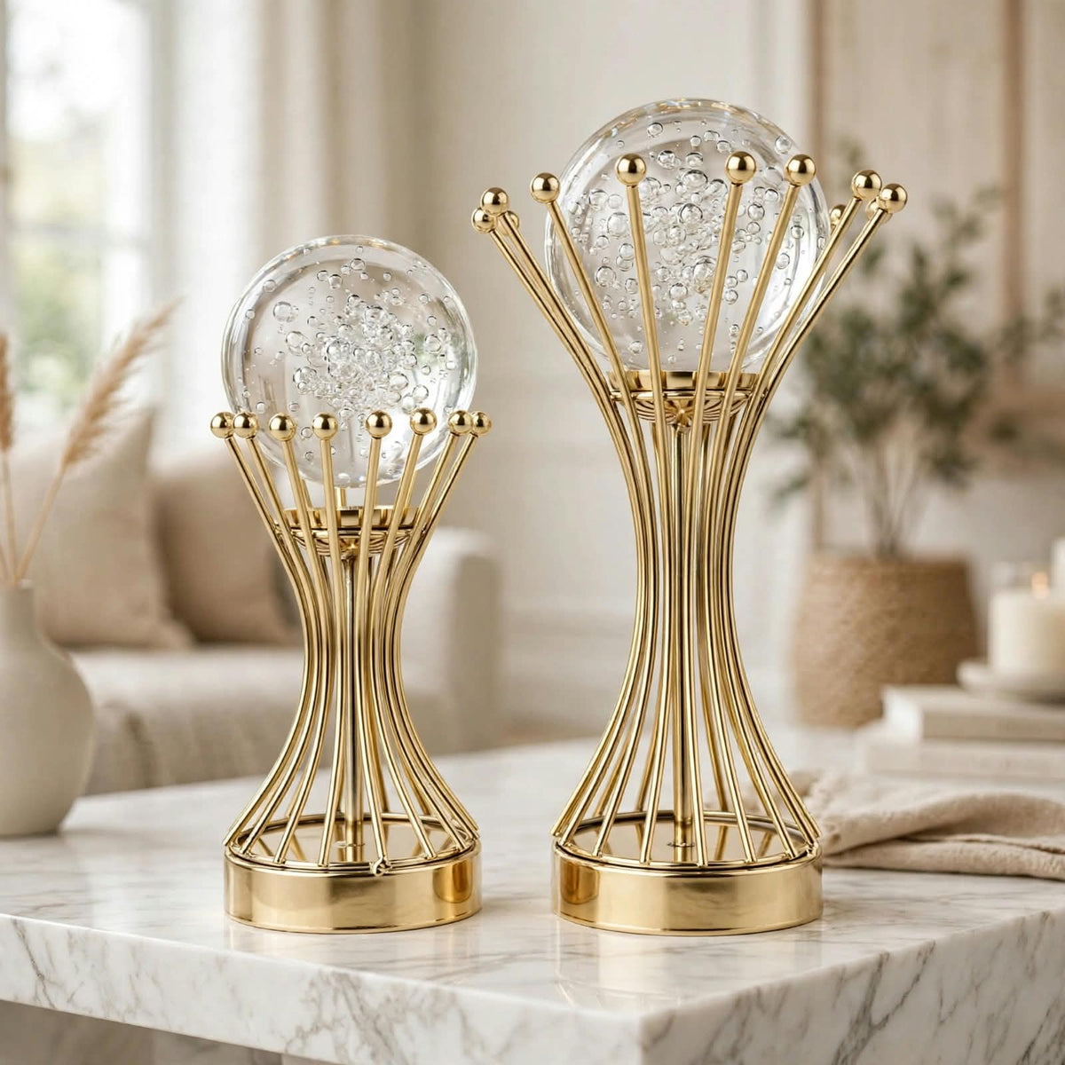 Pair of bubble crystal ball gold crown wire stand sculptures on a marble coffee table in a luxury living room