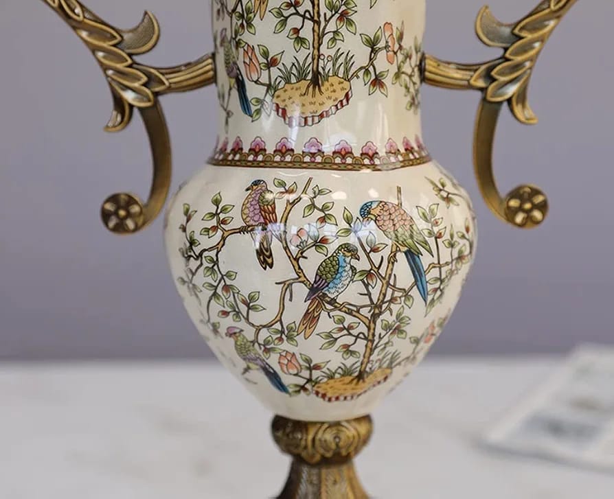 Close-up of bird and floral motif on porcelain vase with brass handles